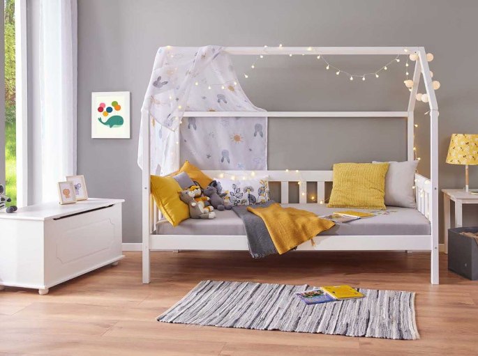 Couchage de 90 cm surmonté d'une ossature en pin laqué blanc dans une chambre d'enfant