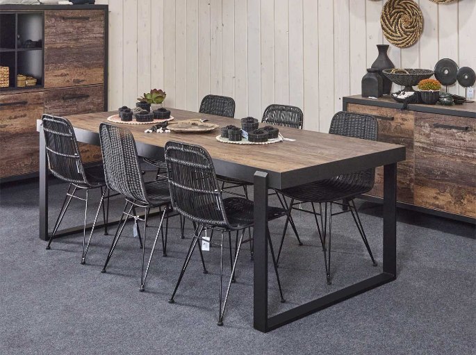 Plateau de table en bois foncé veiné posé sur un piétement métallique
