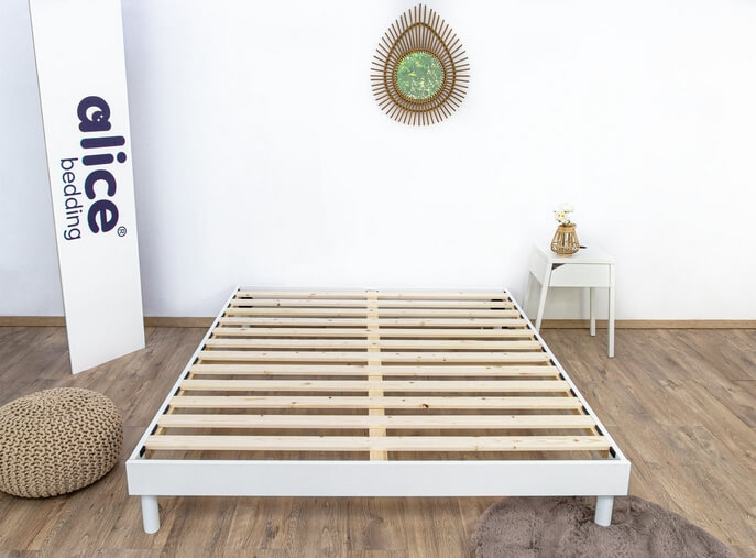 Sommier plancher en bois sous un matelas dans une chambre