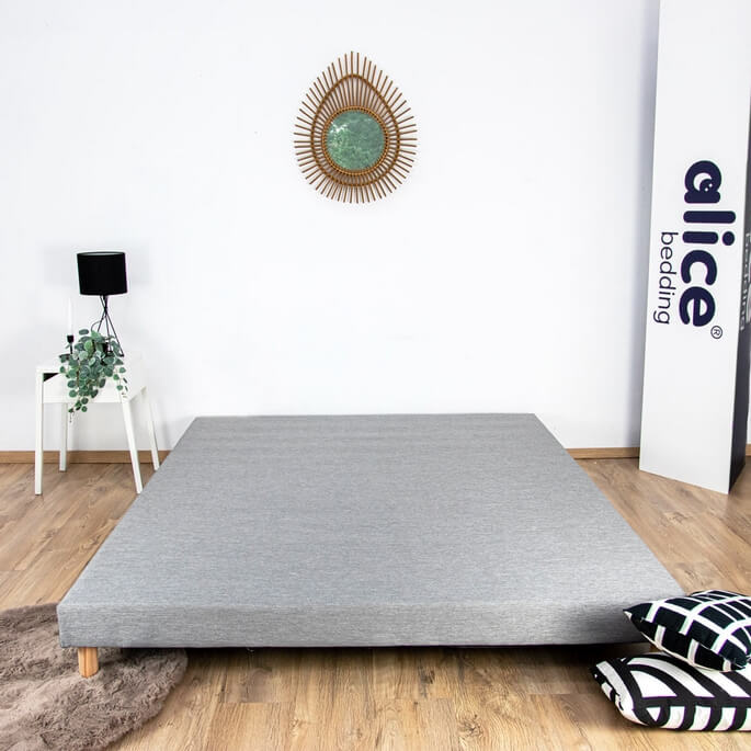 Sommier tapissier recouvert de tissu dans une chambre
